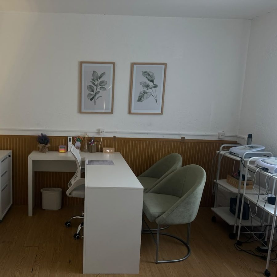Consultório com quadros botânicos e poltronas verdes