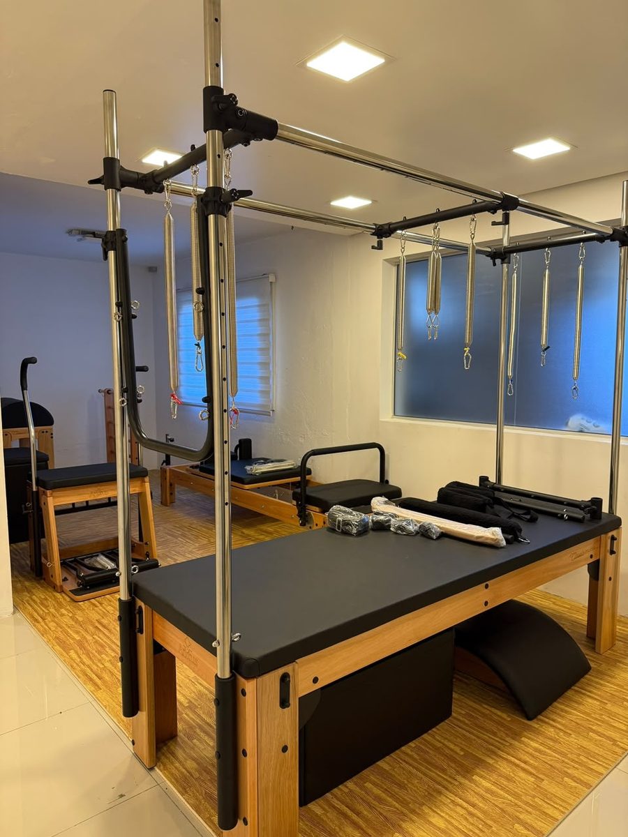 Sala de Pilates com Cadillac, cadeira e reformer
